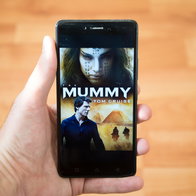 Person holding a mobile phone with the poster for the movie the Mummy from 2017