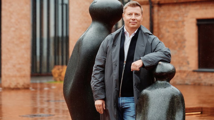 Picture of Denis Kitaev stood next to a sculpture