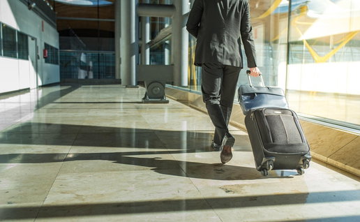 A traveller walking through an airport terminal with a suitcase, representing free movement and social security rights across the European Union.