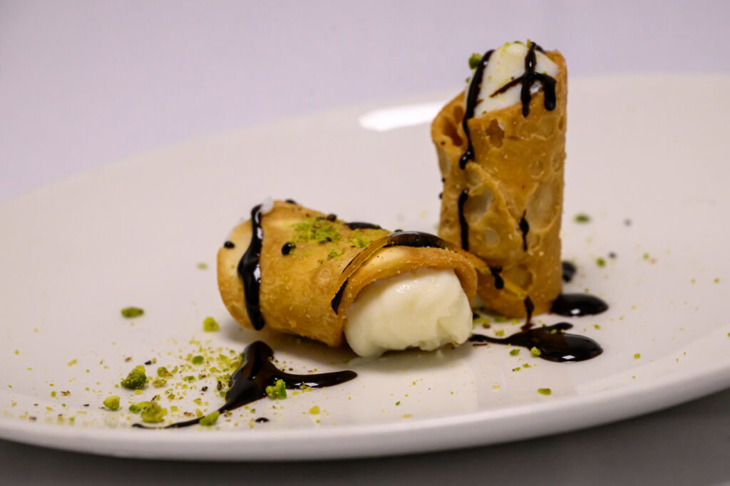 Sicilian cannolo filled with sheep's milk ricotta, dark chocolate, and pistachios.