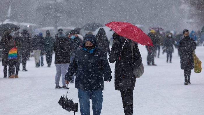 People walk through heavy snowfall as forecasters warn of colder weather and possible snow returning to Spain in May.