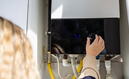 Homeowner adjusting a gas boiler as EU plans phase out of gas heating systems