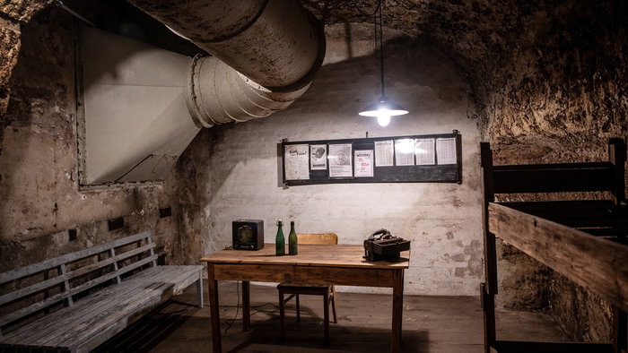Interior of an underground bunker in Germany with wooden benches, bunk beds and ventilation pipes as Europe discusses civil defence preparedness.