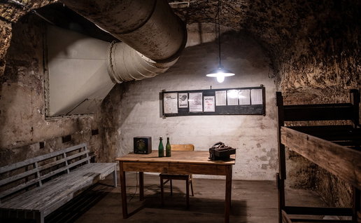 Interior of an underground bunker in Germany with wooden benches, bunk beds and ventilation pipes as Europe discusses civil defence preparedness.