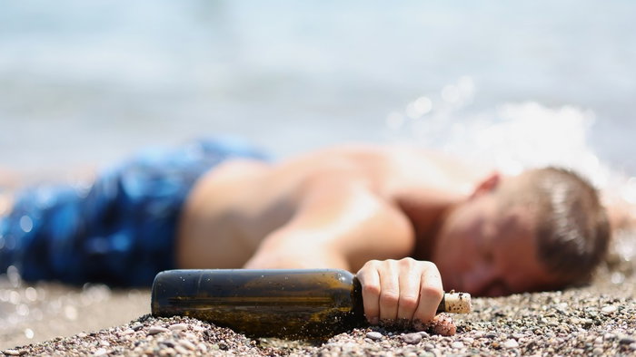 Hungover man asleep on the beach