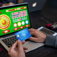 Person holidng a credit card whilst playing at a online casino