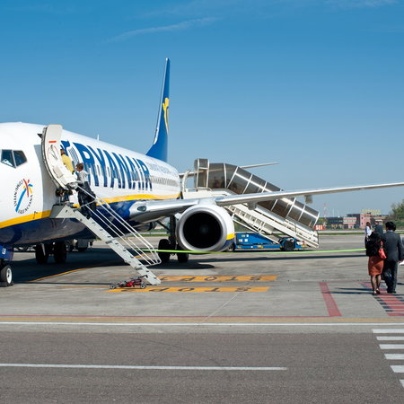 Passengers boarding a Ryanair aircraft on the airport runway before a flight from Spain to a European destination