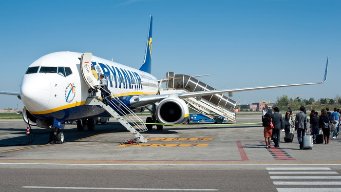 Passengers boarding a Ryanair aircraft on the airport runway before a flight from Spain to a European destination