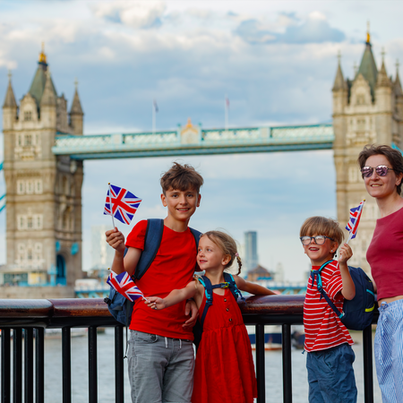 3 children and a woman with Union Jack flags near Tower Bridge