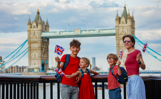 3 children and a woman with Union Jack flags near Tower Bridge