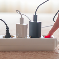 A finger turning the switch on of an extension lead