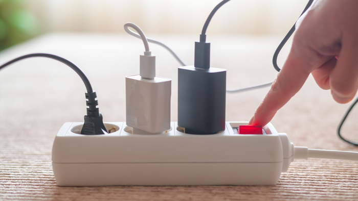 A finger turning the switch on of an extension lead