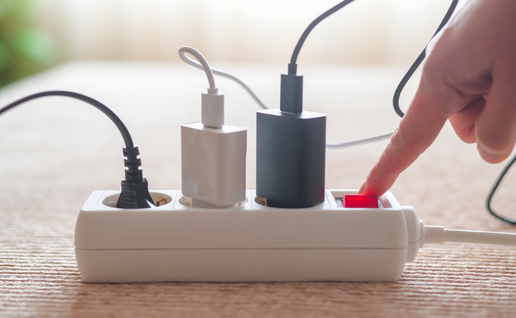 A finger turning the switch on of an extension lead
