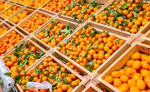 Mandarins in crates on supermarket shelf