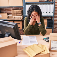 Woman sitting at her desk with her face in her hands