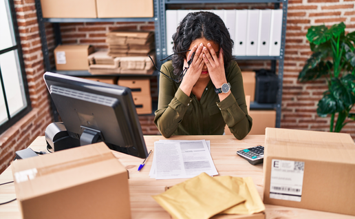Woman sitting at her desk with her face in her hands