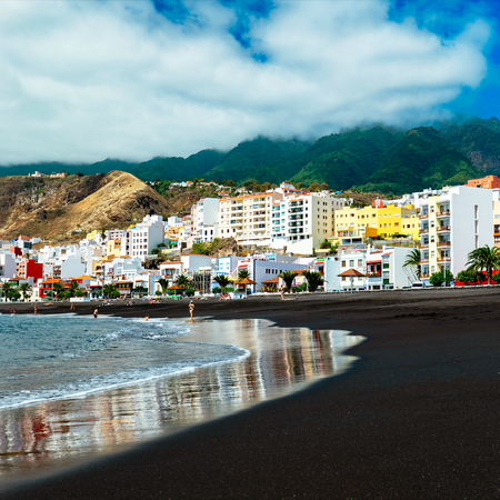 A village near a beach with volcanic sand in the Canary Islands