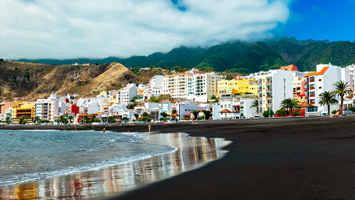 A village near a beach with volcanic sand in the Canary Islands