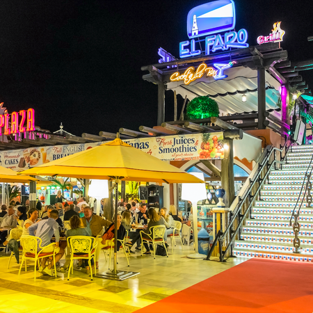 Nightlife in the bars and terraces of a modern shopping center in the tourist city of Playa de las Americas