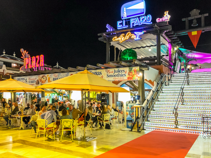 Nightlife in the bars and terraces of a modern shopping center in the tourist city of Playa de las Americas