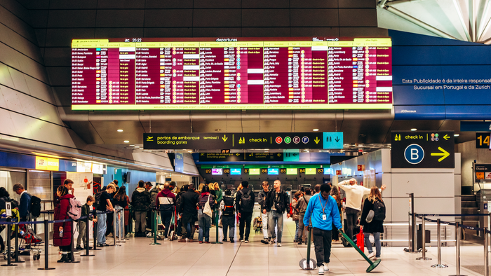Passengers looking at their flight details in an airport