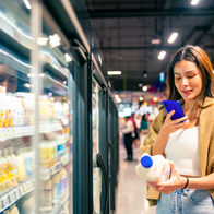 Woman at a supermarket scanning code with her mobile phone