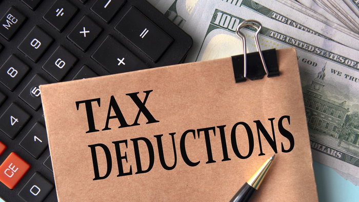 Tax deductions note with calculator and cash illustrating Spain home insurance tax benefit