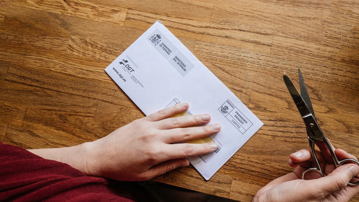 A driver opening an official traffic fine letter from Spain’s DGT after receiving a delayed driving penalty notice.