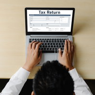 Person sat a laptop filing out a online tax return form