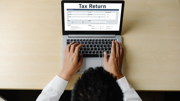 Person sat a laptop filing out a online tax return form