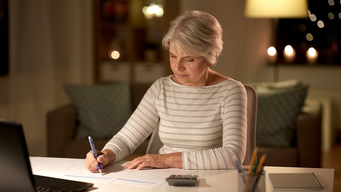 Retired woman reviewing financial paperwork at home as pensioners in Spain gain access to tax exemptions after turning 65.