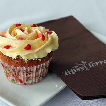 A cake on a plate with a serviette that says "Tipsy Terrace".