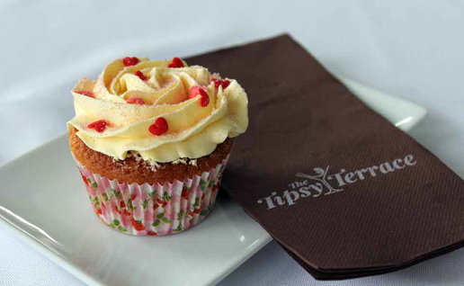 A cake on a plate with a serviette that says "Tipsy Terrace".