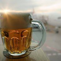 Beer served inside an airport terminal with a passenger plane blurred in the background