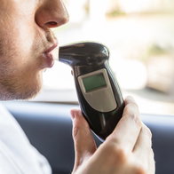 Passenger blowing into breathalyser during roadside alcohol test in Spain