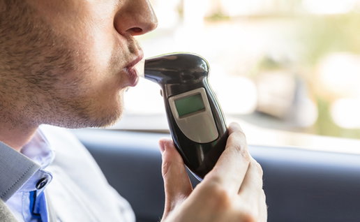 Passenger blowing into breathalyser during roadside alcohol test in Spain