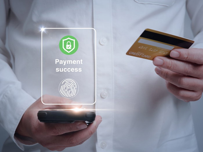 Person making a payment using biometric fingerprint authentication on a bank card
