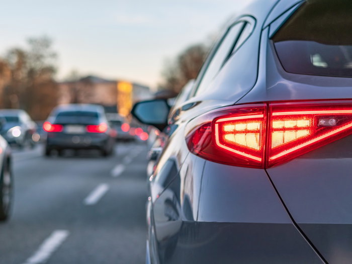 Car brake lights illuminated in traffic as new EU flashing brake light rule approaches