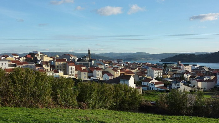 View of Cariño in Galicia, one of Spain's most affordable coastal towns, with houses overlooking the Atlantic coastline.