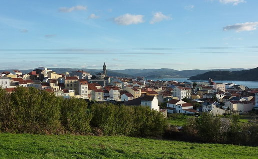 View of Cariño in Galicia, one of Spain's most affordable coastal towns, with houses overlooking the Atlantic coastline.