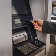 Person using a bank card at a traditional ATM cash machine.