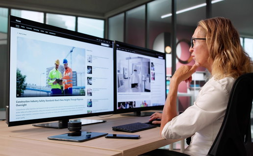 Journalist sat in front of computer screens looking a digital journalism