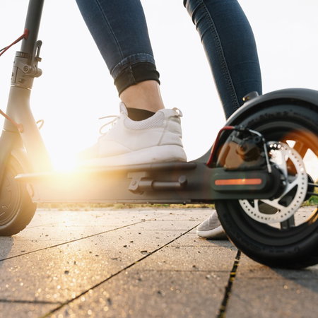 Close up of a person riding an electric scooter outdoors as Spain introduces new traffic restrictions for scooter users in certain urban areas.