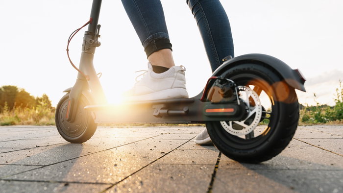 Close up of a person riding an electric scooter outdoors as Spain introduces new traffic restrictions for scooter users in certain urban areas.