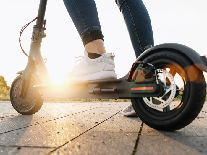 Close up of a person riding an electric scooter outdoors as Spain introduces new traffic restrictions for scooter users in certain urban areas.