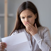Woman looks shocked while reading a letter as Hacienda prepares to send warning notices over tax return mistakes in Spain.