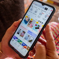 Woman shopping online on her smartphone while browsing discounts and flash sales on an ecommerce app.