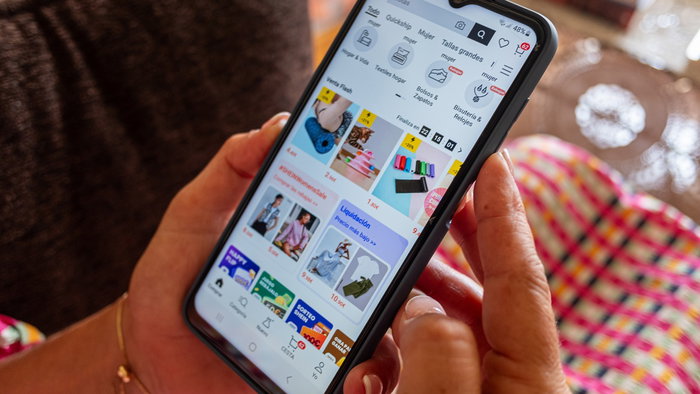 Woman shopping online on her smartphone while browsing discounts and flash sales on an ecommerce app.