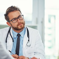 A male patient in his 50s discussing medical options with a supportive doctor during a prostate cancer screening consultation.