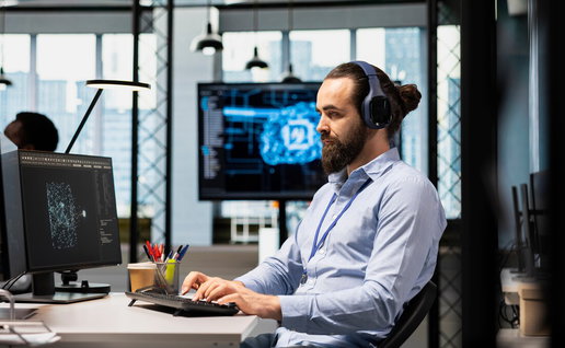 Man working on a computer using artificial intelligence tools in a modern office environment in Spain